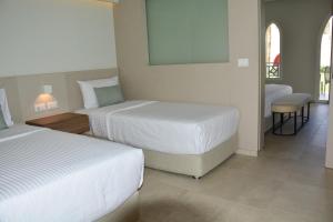 a hotel room with two beds and a mirror at Reef Oasis Beach Aqua Park Resort in Sharm El Sheikh