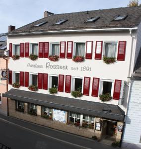 ein Gebäude mit roten Rollläden auf einer Straße in der Unterkunft Hotel Rossner in Münchberg