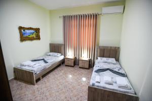 a room with two beds and a window at Guesthouse Alemannia in Berat