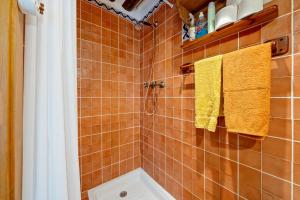 a bathroom with orange tiles and yellow towels at Ca La Germandat Paüls in Paúls +21 photos