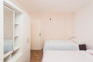 two beds in a small room with white walls at Rental São José - Acomodações Residenciais III in São José +33 photos