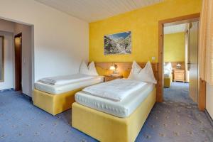 - 2 lits dans une chambre d'hôtel aux murs jaunes dans l'établissement Apartment in Zillertal near Spieljochbahn, à Fügen