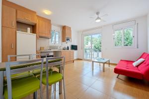 a kitchen and living room with a red couch at Dorada Apartment Lluna in Calafell