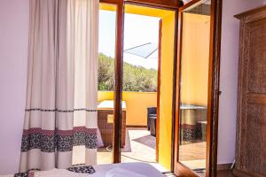 une chambre avec une porte coulissante en verre avec un balcon dans l'établissement Borgo Arborea Charming Retreat, à Santa Teresa Gallura