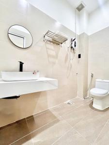 a bathroom with a sink and a toilet and a mirror at Cozy Home Airport - Self check-in 247 in Ho Chi Minh City