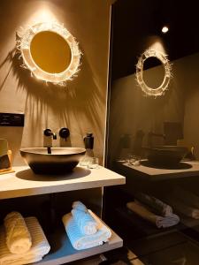 a bathroom with a sink and mirrors and towels at B&B Leonie in Alveringem +86 photos