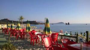 a group of chairs and tables and umbrellas on a beach at B&B La Torre in Loceri