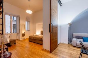 una camera da letto con un letto e un divano in una stanza di GuestHost - Dimora del Barone a Salerno