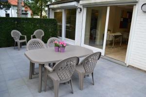 a table and chairs with flowers on a patio at B&B Lobelia-Brugge in Bruges +31 photos