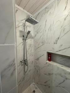 a bathroom with a shower with white marble walls at Заграйка in Snidavka