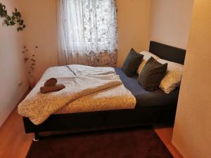 a bed in a bedroom with a window with a pair of towels at Maison Room in Karlsruhe