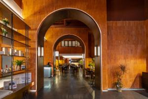 廈門市にあるXiamen Zhongshan Road Pedestrian Street Qulistar Hotelのテーブルと椅子のあるレストランのアーチ道