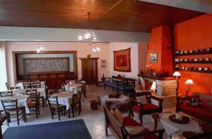 un restaurante con mesas y sillas y una chimenea en Morfeas, en Karpenisi