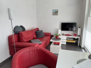 a living room with a red couch and a tv at Hasenwinkel 6 in Gelbensande
