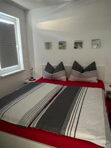 a large bed in a room with a red and white at Hasenwinkel 6 in Gelbensande
