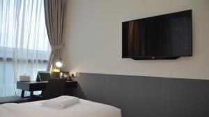 a hotel room with a bed and a desk with a television at VicHaus Serviced Apartment in Singapore