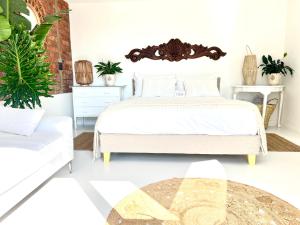 a bedroom with a bed and a couch at Sunny Bali Cottage in Mossel Bay