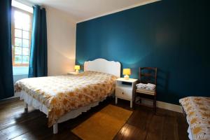 a bedroom with a bed and a blue wall at La ferme de lapeyrousse in Saint-Vitte-sur-Briance