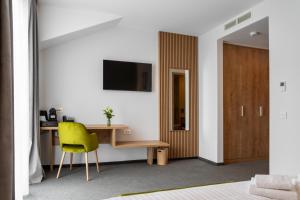 a bedroom with a desk and a yellow chair at No Pardon Hotel in Satu Mare