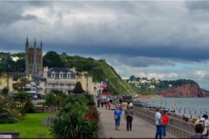 a group of people walking on a bridge near the water at Gem Cottage in Teignmouth