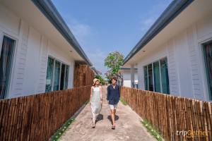 a man and a woman walking down a fence at พีพี วิลล่า เกาะล้าน in Ko Larn