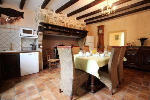a dining room with a table and a kitchen at La ferme de lapeyrousse in Saint-Vitte-sur-Briance