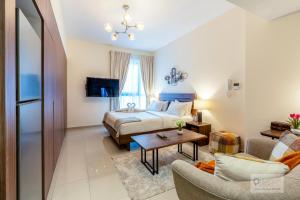 シャルジャにあるCapital Stay - Studio Apt in Al Zahia Sharjahのベッドとリビングルームのある寝室