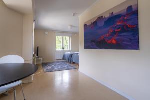 a room with two beds and a large painting on the wall at Kotimaailma Villa Hortus - for 2 in Turku