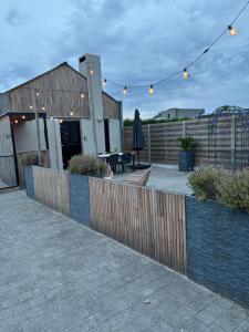 a patio with a fence and a table with a umbrella at Guesthouse 66 in Lommel