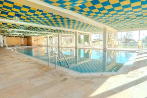 a large swimming pool with a blue and yellow ceiling at Ferienwohnung BergOase mit Pool & Sauna in Scheidegg