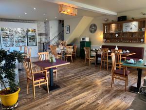 a restaurant with tables and chairs in a room at Hotel Le Crist Al, Front de mer, chambres climatisées et son studio non climatisé, proche du centre ville in Saint-Georges-de-Didonne