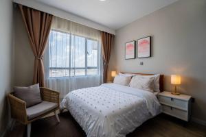ナイロビにあるKapri Nairobi 2BR Suite w Pool Gym near JKIA SGRのベッドルーム1室(ベッド1台、窓、椅子付) +43枚の写真