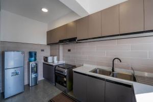 ナイロビにあるKapri Nairobi 2BR Suite w Pool Gym near JKIA SGRのシンクと冷蔵庫付きのキッチン