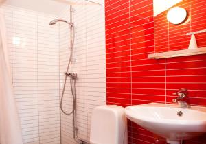 a red and white bathroom with a sink and a shower at Kvibergs Stugor - Cottages in Gothenburg