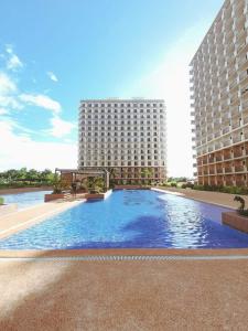 a large swimming pool in front of a large building at Laugh tale Staycation in Suba +9 photos
