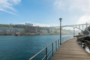 un ponte su un fiume con una passerella di legno di Vibrant Host Solutions-Maria Da Afurada a Vila Nova de Gaia