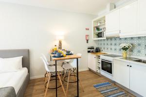 una piccola cucina con tavolo e sedie in una stanza di Vibrant Host Solutions-Maria Da Afurada a Vila Nova de Gaia