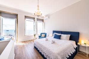 una camera da letto con un letto grande con testiera blu di Vibrant Host Solutions-Maria Da Afurada a Vila Nova de Gaia