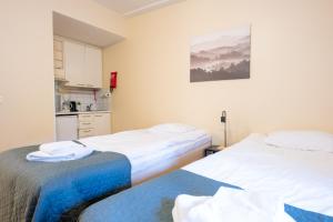 - 2 lits dans une chambre avec cuisine dans l'établissement Kotimaailma Villa Hortus - Homely Studio for 2, à Turku