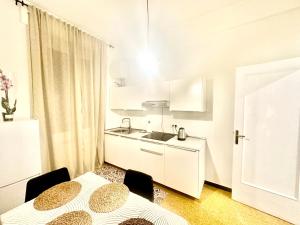 a white kitchen with two tables and a sink at The Center Residence in Genoa