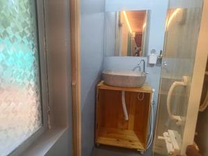 a bathroom with a sink on a wooden stand at Peaceful Abode in Auroville