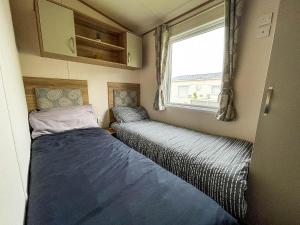 En eller flere senge i et værelse på CaravanSleeps6-HotTub-Garden-WaterWonderland + 11 billeder