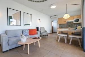 a living room and kitchen with a couch and a table at HD Parque Cristobal Tenerife in Playa de las Americas