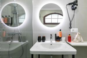 a bathroom with a sink and two mirrors at HD Parque Cristobal Tenerife in Playa de las Americas