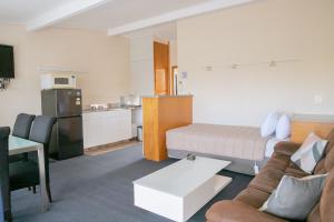 a living room with a couch and a kitchen at Tuki Tuki Motel in  Waipukurau