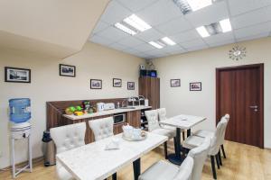 une salle à manger avec des tables et des chaises blanches dans l'établissement Silvija House, à Vilnius