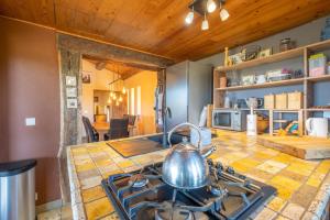a kitchen with a stove with a tea kettle on it at Maison Time-out in Villevieille