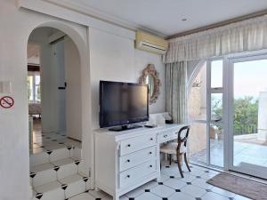 a living room with a television on a white dresser at Villa Bel Fiori Apartment - 2 Sleeper in Ballito