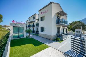 斯卡拉伯塔麦斯Kataleya Poolside Suites的一栋白色的大楼，前面有一片草坪