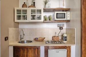 a kitchen with a sink and a microwave at Corte Cenci House in Tivoli